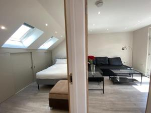 ein Schlafzimmer mit einem Bett und ein Wohnzimmer mit einem Sofa in der Unterkunft Cheviot loft in London