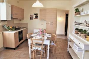 a kitchen with a table and chairs in a room at CLAUDIA VACANZA TOSCANA - Appartamento Melograno -10 min da Siena in Sovicille