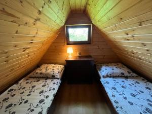 sypialnia z 2 łóżkami w drewnianym domku w obiekcie DREWNIANE DOMKI pod brzozami w Karwii