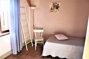 een kleine slaapkamer met een bed en een stoel bij Casa vacanze CLAUDIA 2- SIENA a 10 min in Sovicille