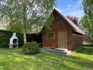 Cette petite maison en bois dispose d'une fenêtre et d'une porte. dans l'établissement DREWNIANE DOMKI pod brzozami, à Karwia