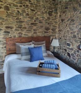 - une chambre avec un grand lit et un mur en pierre dans l'établissement MINI PICONEIRO II, à Pravia