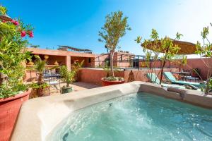 una piscina en un patio trasero con árboles y plantas en Riad L'orange Bleue, en Marrakech