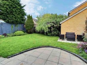 a garden with two chairs and a lawn at Home in Solihull - Near NEC, BHX & Solihull Town Centre in Birmingham