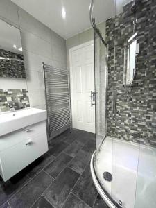 a bathroom with a shower and a sink and a tub at Home in Solihull - Near NEC, BHX & Solihull Town Centre in Birmingham