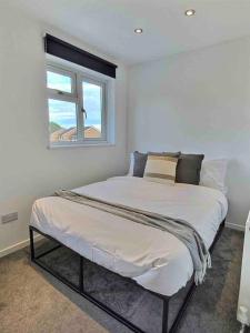 a bedroom with a large bed with a window at Home in Solihull - Near NEC, BHX & Solihull Town Centre in Birmingham
