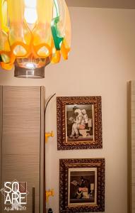 um candelabro por cima de um frigorífico e duas fotografias na parede em MR SQUARE apartment em Catânia