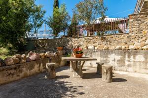 una mesa de picnic con una maceta encima de una pared de piedra en Le Volte ( Matrimoniale esclusiva più divani letto), en Gambassi Terme