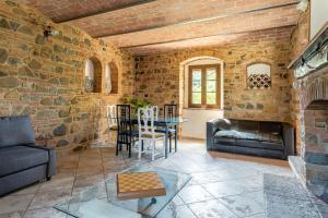 sala de estar con pared de piedra en Le Volte ( Matrimoniale esclusiva più divani letto), en Gambassi Terme