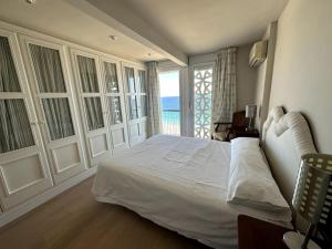 a bedroom with a large bed with a view of the ocean at Primera Linea Playa de LEVANTE in Benidorm