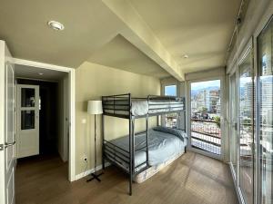 a bedroom with a bunk bed and a balcony at Primera Linea Playa de LEVANTE in Benidorm