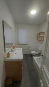 een badkamer met een wastafel, een toilet en een spiegel bij Apartamento Río Maior in Muros