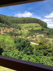 a view of a green hill with trees and houses at Pousada Irmãos Tonoli in Venda Nova do Imigrante