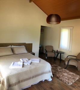 a bedroom with a bed with towels on it at Pousada Irmãos Tonoli in Venda Nova do Imigrante +15 photos