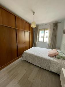 - une chambre avec un lit et des placards en bois dans l'établissement MALVARROSA BEACH FAMILIAR, à Valence