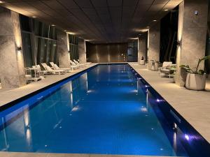 a large swimming pool with blue water in a building at WSP 3B2B apartment in CBD with free parking in Melbourne