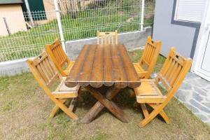 un tavolo in legno con quattro sedie in legno intorno di Vila Dimitrijevic Lisine a Despotovac