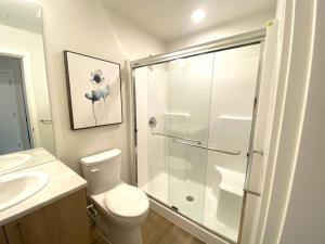 uma casa de banho com um chuveiro, um WC e um lavatório. em Lovely Brand New Suite em Sidney