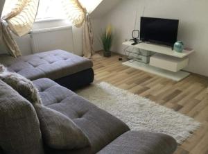 a living room with a couch and a flat screen tv at Kiara Apartman in Siófok