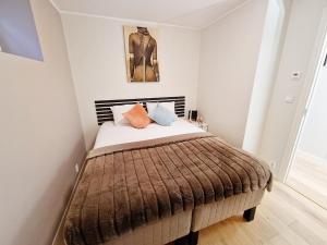 sypialnia z łóżkiem z brązowym kocem w obiekcie Ibsens apartaments w Bergen