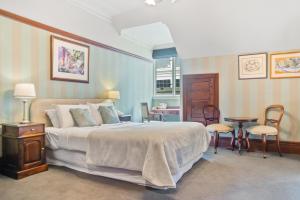 a bedroom with a bed and a table and chairs at Wellesley Boutique Hotel in Wellington