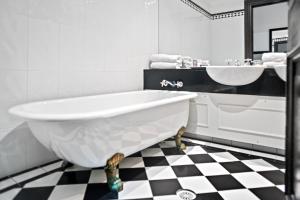 Baño blanco con bañera y lavamanos en Wellesley Boutique Hotel, en Wellington