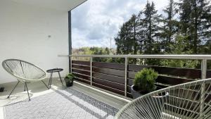 einen Balkon mit einem Stuhl und Blick auf die Bäume in der Unterkunft INSIDE WINTERBERG - Design Apartment - Ski Bike Sauna in Winterberg