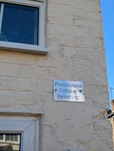 ein weißes Schild an der Seite eines Gebäudes in der Unterkunft Flemingate Cottage, Beverley in Beverley