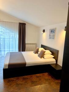 a bedroom with a large bed with white sheets and pillows at Casa Servus in Mamaia Sat/Năvodari