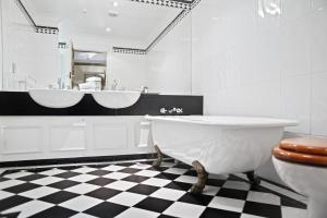 a bathroom with two sinks and a tub and a toilet at Wellesley Boutique Hotel in Wellington +14 photos