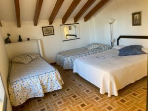 une chambre avec deux lits et un parquet dans l'établissement 1era linea de playa VILLA MARGARET Cullera Marenyet, à Cullera