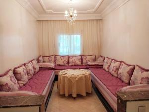 a living room with a large couch and a table at Appartement Martil , très proche de la plage in Martil