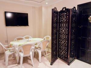 a dining room with a table and chairs and a tv at Appartement Martil , très proche de la plage in Martil