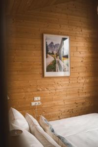 a bedroom with a wooden wall with a picture on the wall at Naturnahes Familienchalet mit Garten - Wifi - Netflix - nur 15 Minuten vom Chiemsee und 35 Minuten von München entfernt in Vogtareuth