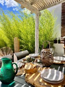 un tavolo con un vaso verde e dei piatti sopra di Pátio dos 8 - Alentejo a Vale de Santiago