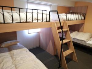 a room with two bunk beds and a bed at Hotel Raffinato Chitose in Chitose