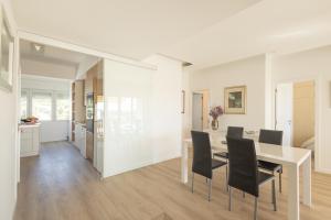 - une salle à manger et une cuisine avec des murs blancs, une table et des chaises dans l'établissement OceanFront & Big Terrace Private Condo, à Oeiras