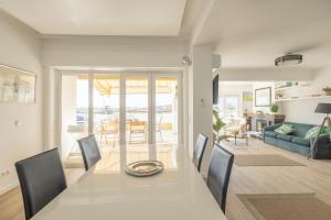 una sala da pranzo e un soggiorno con tavolo e sedie di OceanFront & Big Terrace Private Condo a Oeiras