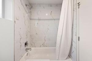 a white bathroom with a tub and a shower curtain at Walkable DTPH Studio w/ Pool and Parking in Phoenix