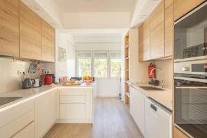 una cucina con mobili bianchi e una grande finestra di OceanFront & Big Terrace Private Condo a Oeiras Altre 22 foto