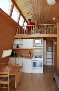 dwie osoby siedzą na drugim piętrze malutkiego domku w obiekcie Dancamps Kolding City w mieście Kolding