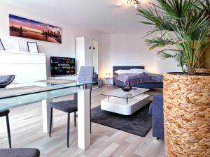 ein Schlafzimmer mit einem Bett, einem Tisch und einer Topfpflanze in der Unterkunft HappySide BrightLines - Parkplatz - Nespresso - WLAN in Leipzig