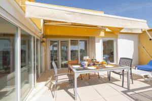 un tavolo e sedie su un patio con tenda da sole di OceanFront & Big Terrace Private Condo a Oeiras