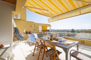 una sala da pranzo con tavolo e sedie su un balcone di OceanFront & Big Terrace Private Condo a Oeiras