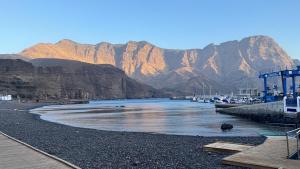 a body of water with mountains in the background at Casa BIMBA Agaete con terraza y ducha exterior in Agaete