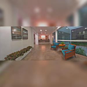 an empty lobby with chairs and tables in a building at Hotel Conceição in Linhares