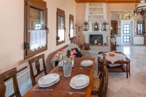 uma sala de jantar com uma mesa e cadeiras e uma lareira em Blue Panorama Villas em Giannoudi