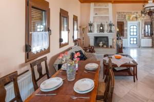 a dining room with a table and chairs and a fireplace at Blue Panorama Villas in Giannoudi