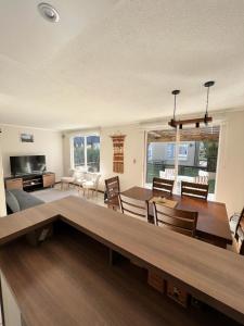 una sala de estar con una gran mesa de madera y sillas en Casa nueva en Pucón, en Pucón