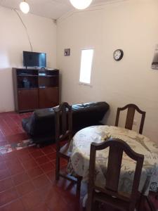 een woonkamer met een tafel en stoelen en een bank bij H2Otel in Salta